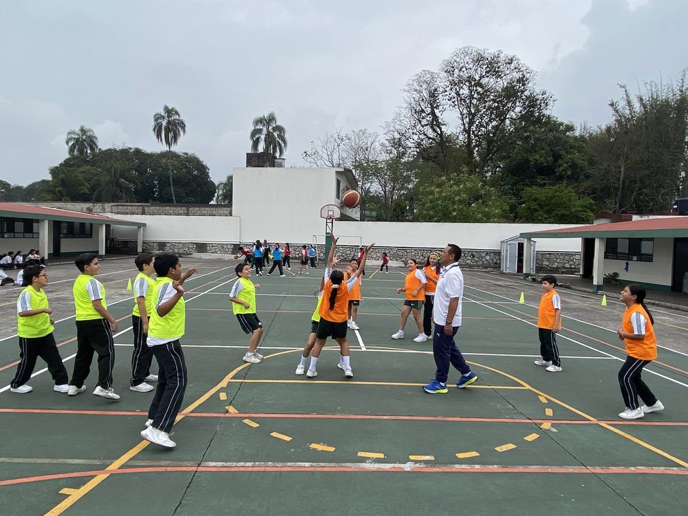 Alumnos de primaria jugando basquetbol